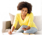 Woman on couch doing taxes.